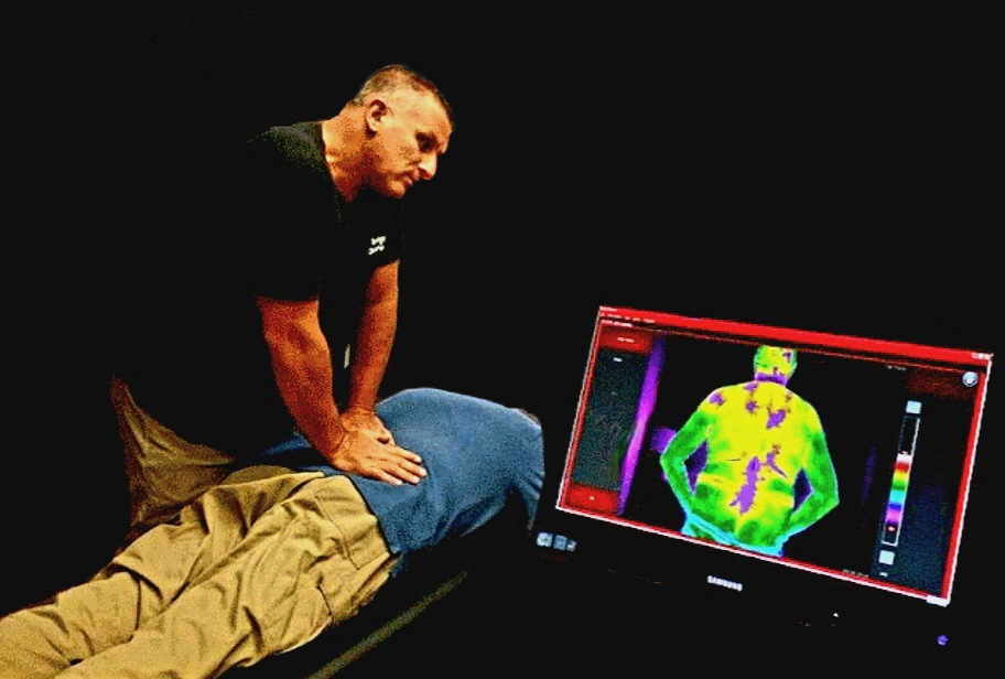 Dr. Piana using thermal imaging to make a chiropractic adjustment